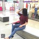 A woman sitting on a bench in a shopping mall.