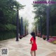 A woman in a red dress walking down a walkway.