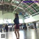 A woman in a black shirt and red skirt standing in an airport.