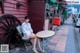 A woman sitting at a table in front of a building.