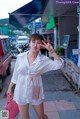 A woman in a white shirt and white shorts posing for a picture.