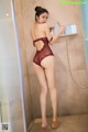 A woman in a red lingerie standing in a shower.