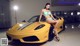 A woman in a bikini sitting on a yellow sports car.