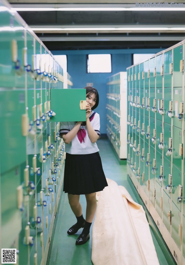 A woman standing in front of a row of lockers.