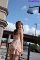 A woman in a floral dress is posing for a picture.