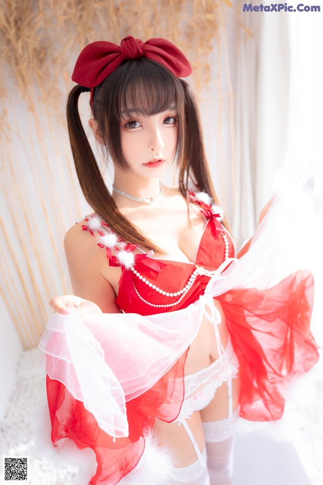 A woman in a red and white lingerie posing for a picture.
