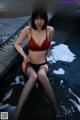 A woman in a red bra and black panties sitting in a pool.